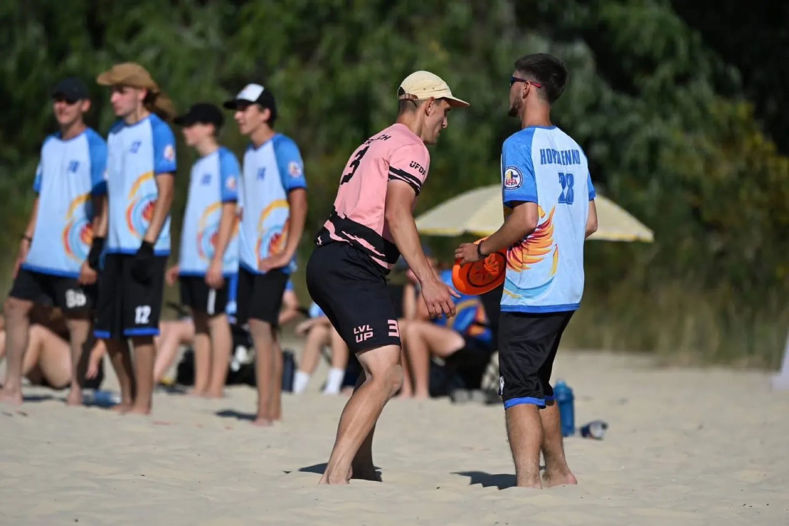 Coach talks with a player at the beach.