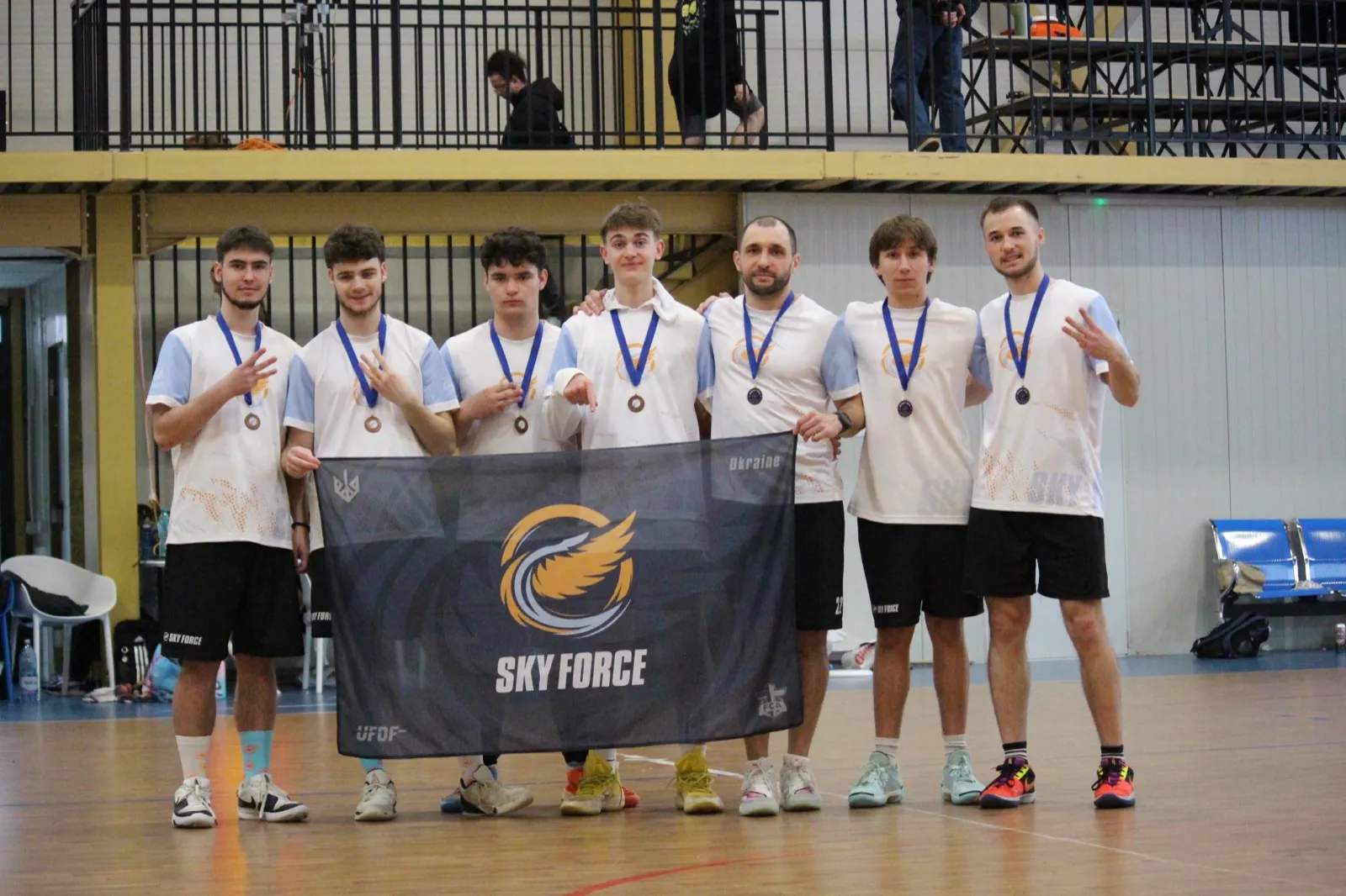 Boys hold the SkyForce banner after a medal.