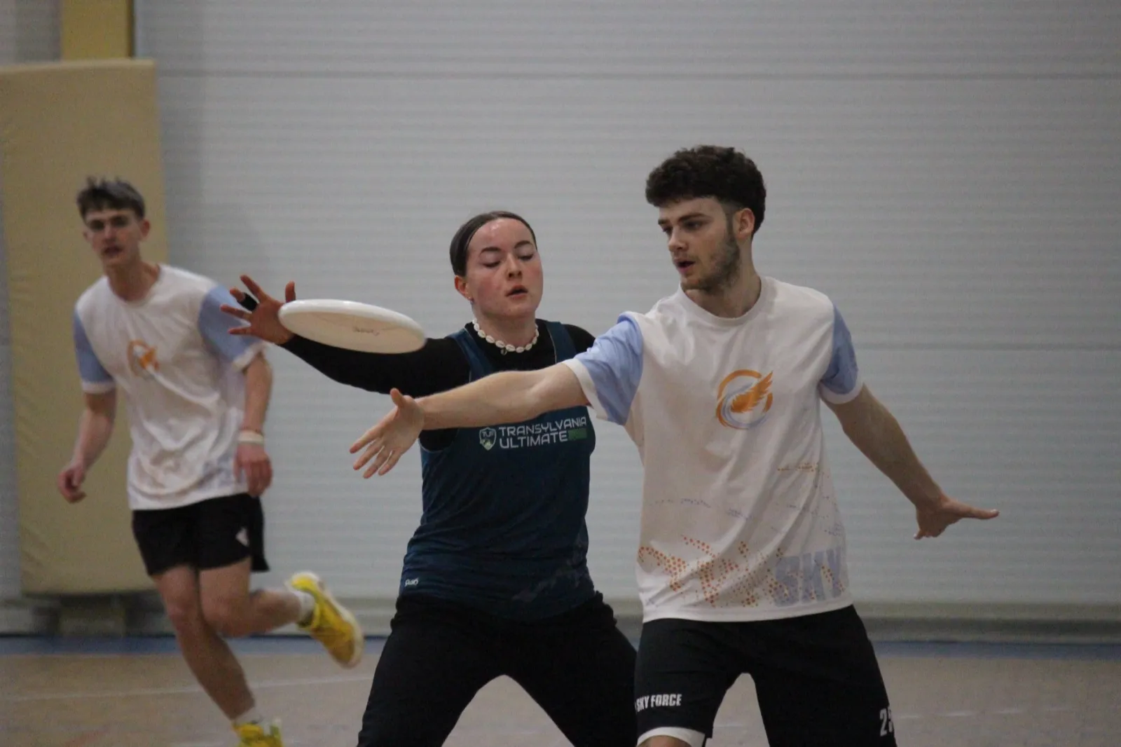 Players contest the disc indoors.