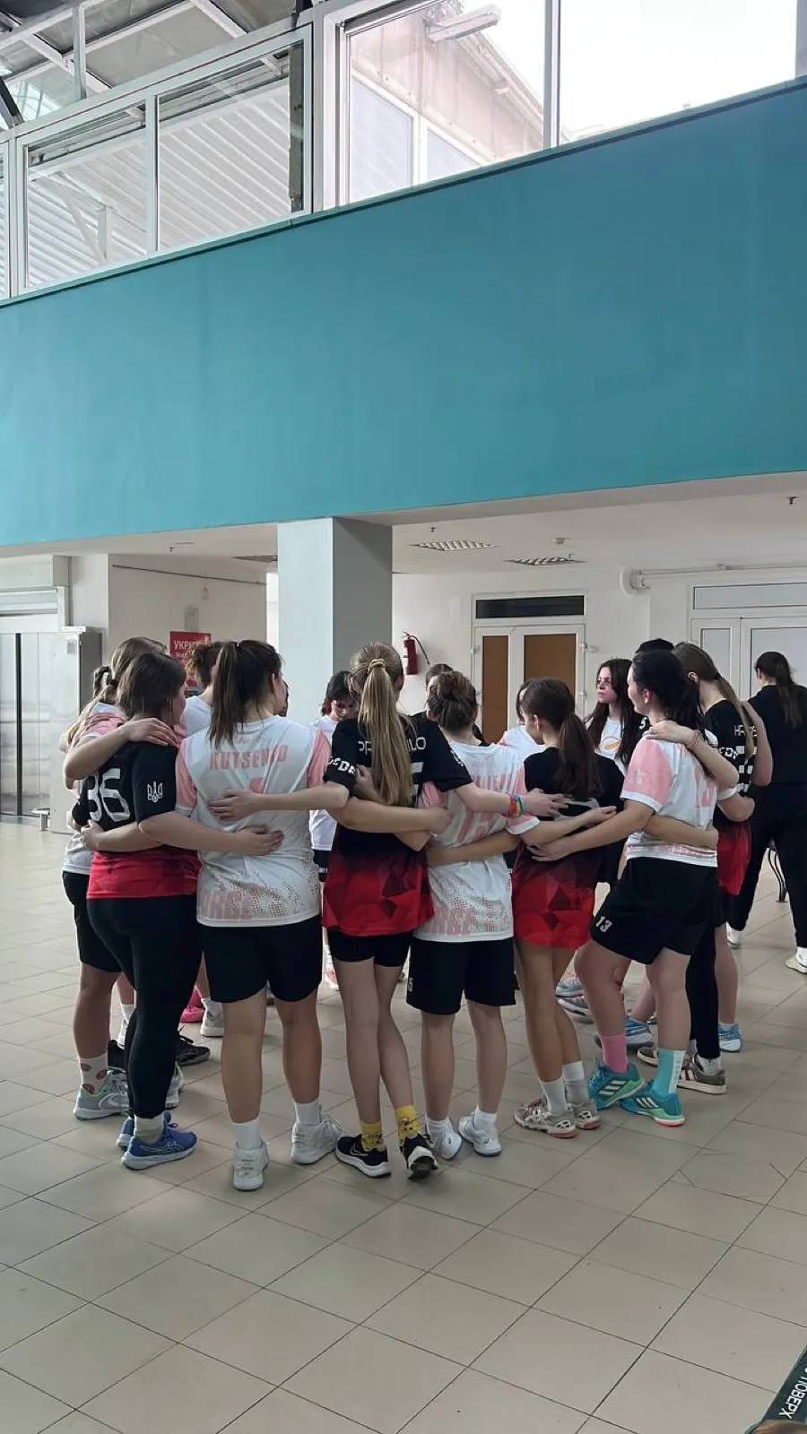 Girls team in a tight hug-circle.