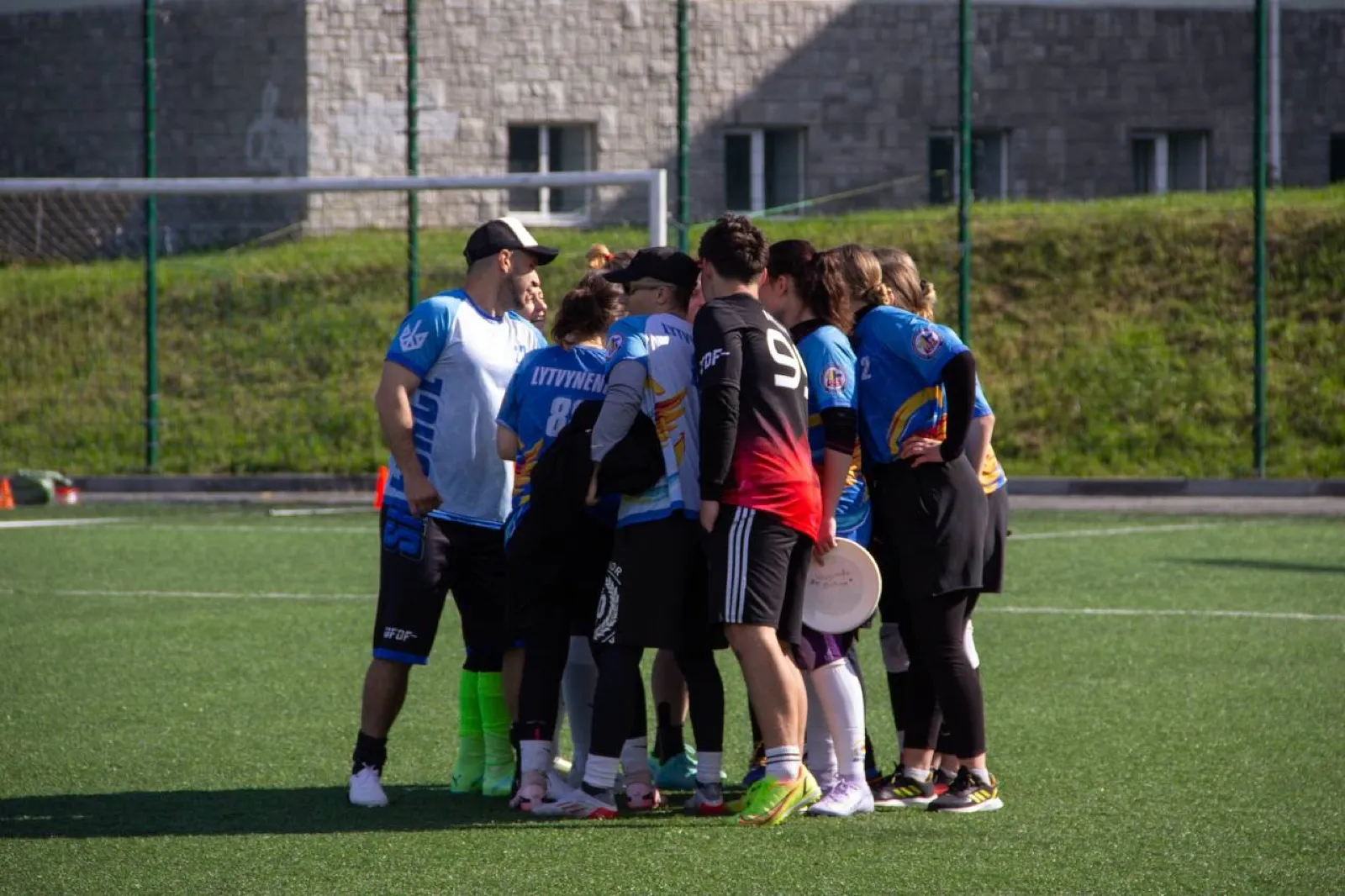 Team huddle on the grass.