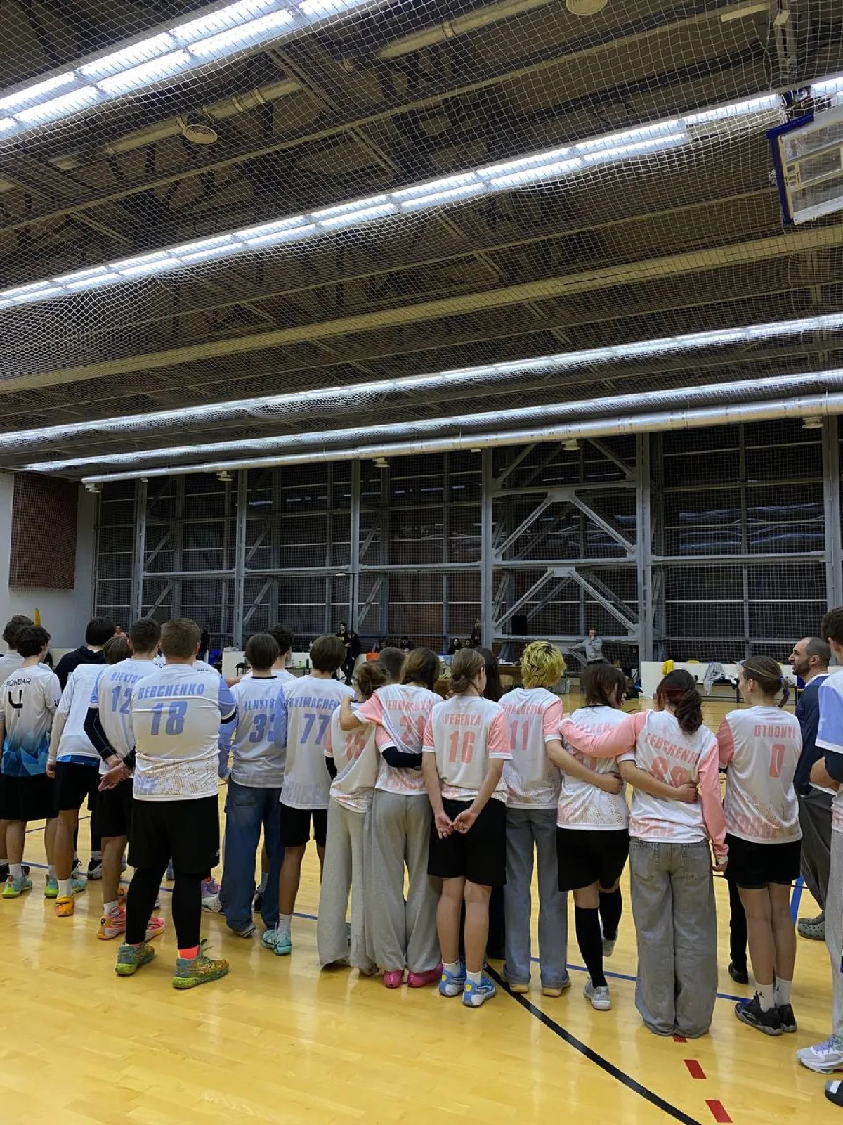Players watch the next game from the sideline.